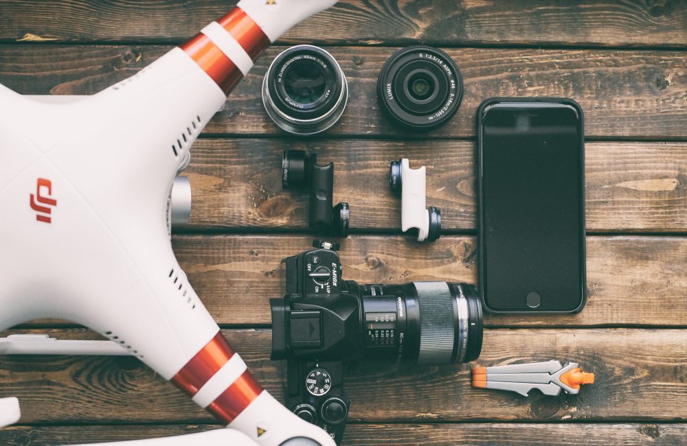 aaron-burden-205148-unsplash Drone laying on a table with camera and other photography equipment